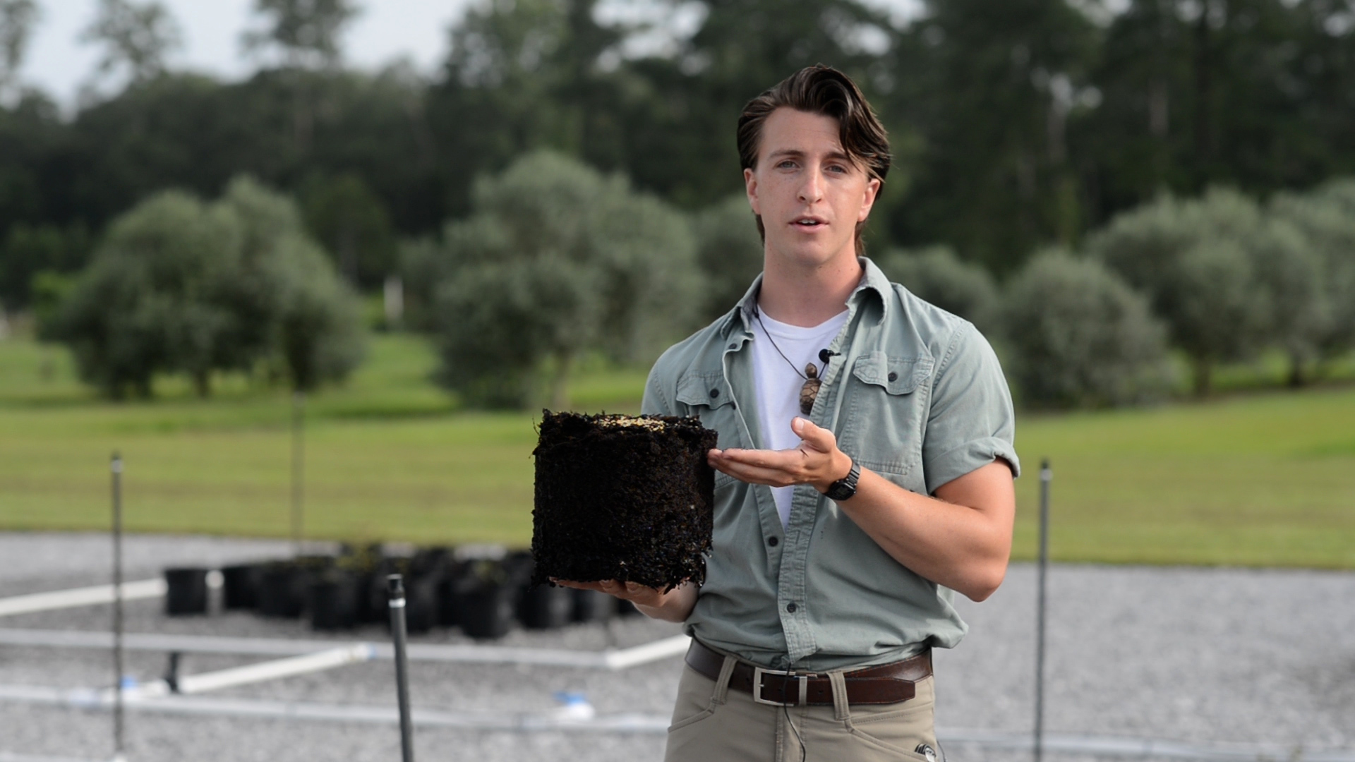 Young man standing outdoors giving a talk.